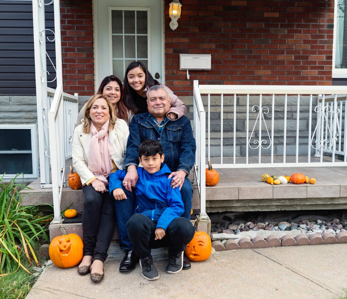 Smiling family sitting on front steps