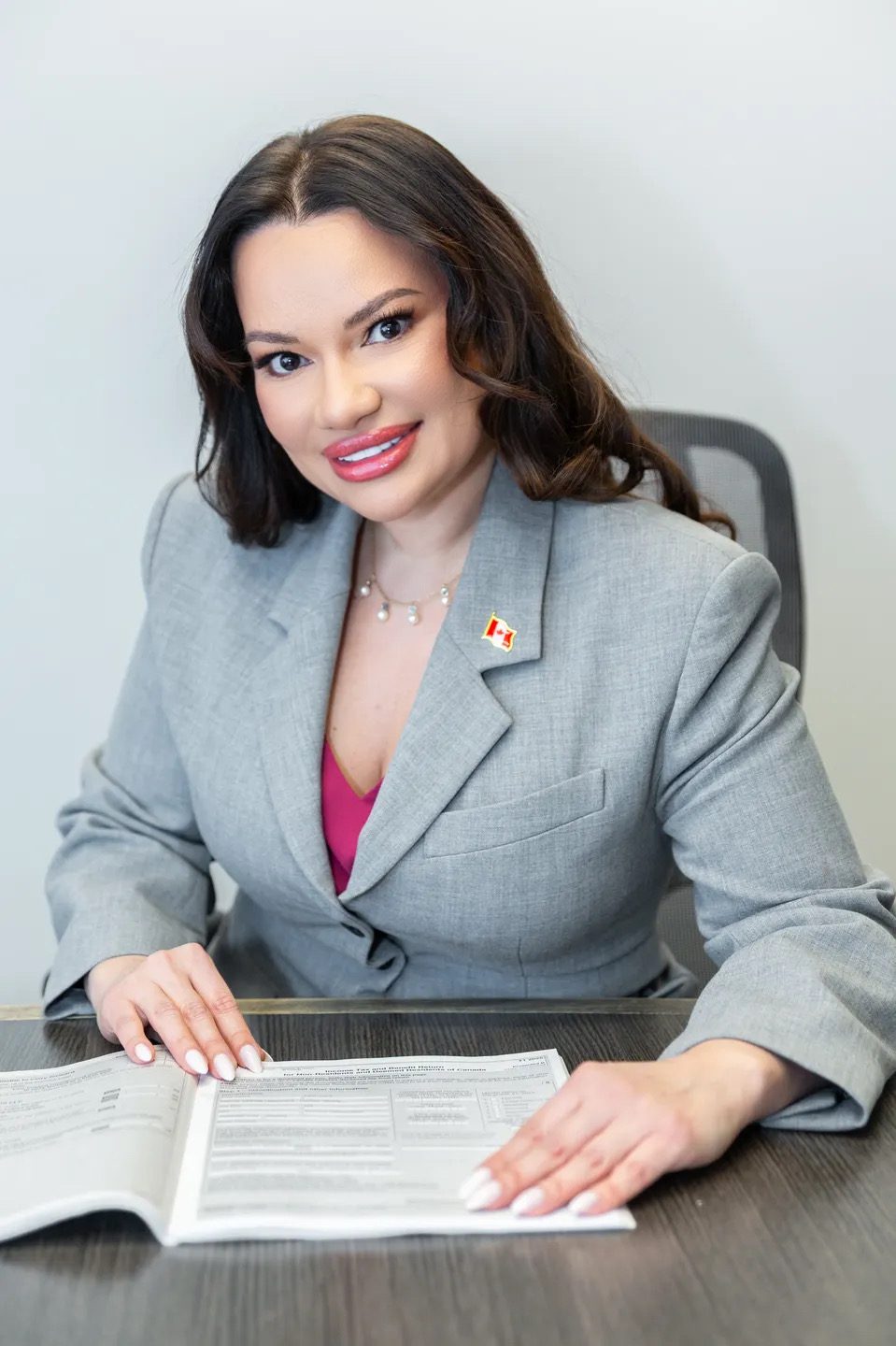 Professional woman in gray suit smiling at the camera.