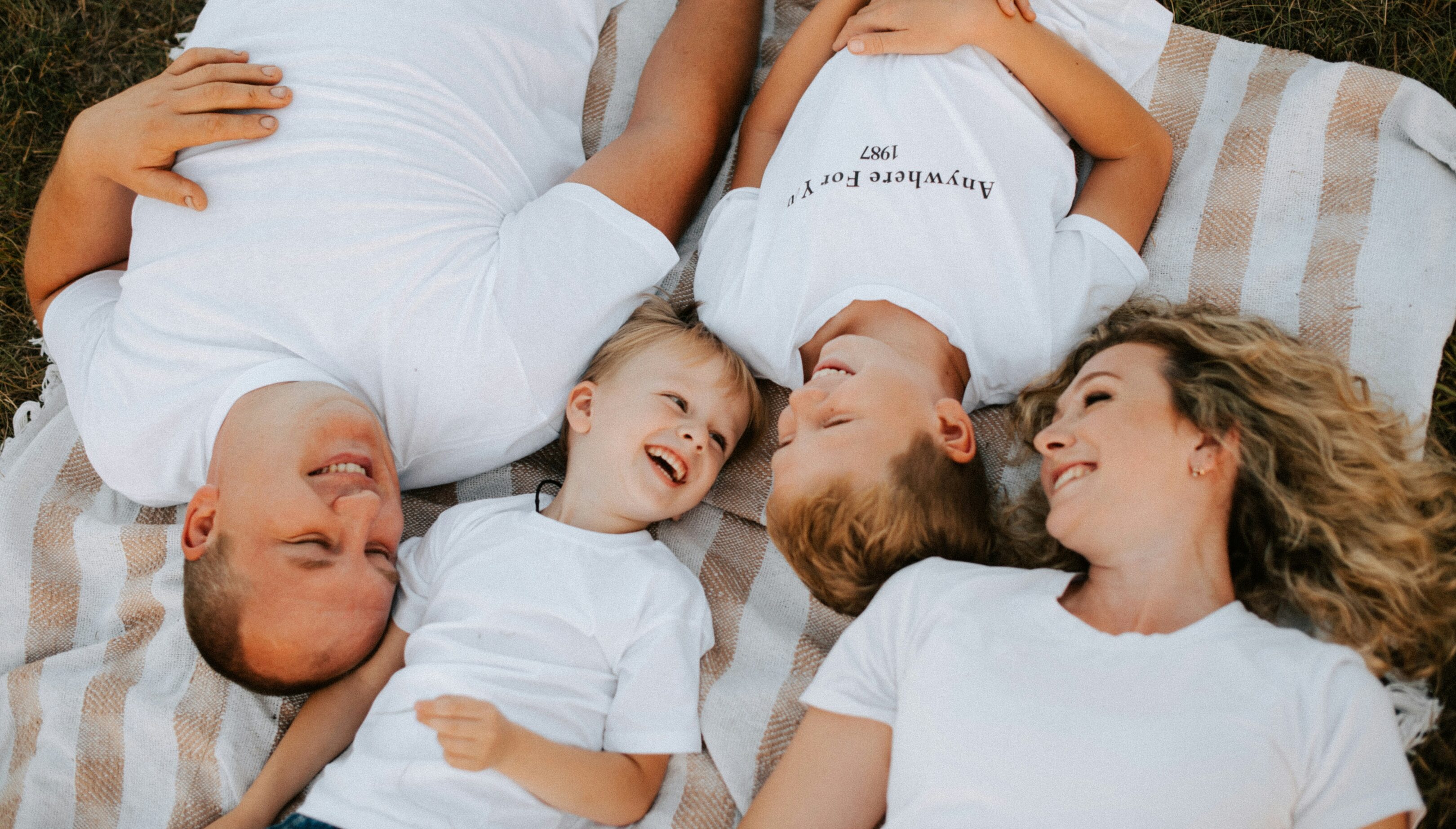 Family lying together smiling and enjoying quality time.